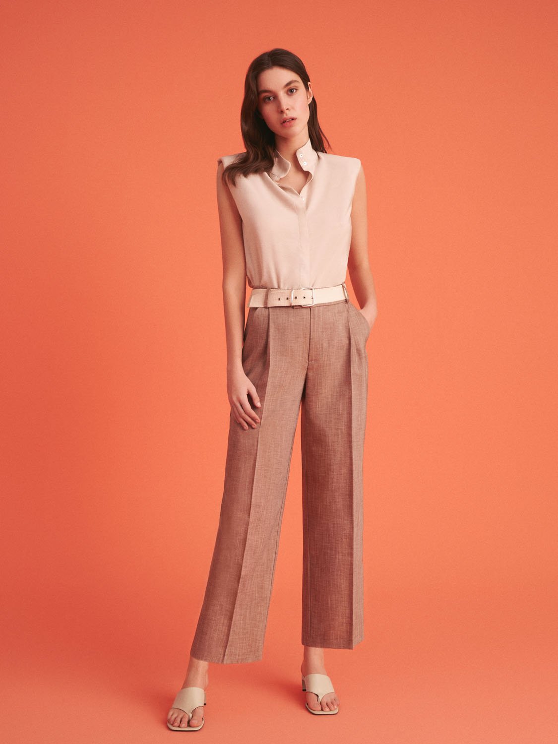 A pair of stylish ankle-length pleated high-waisted pants with a metal buckle belt, showcasing a chic design suitable for summer wear.