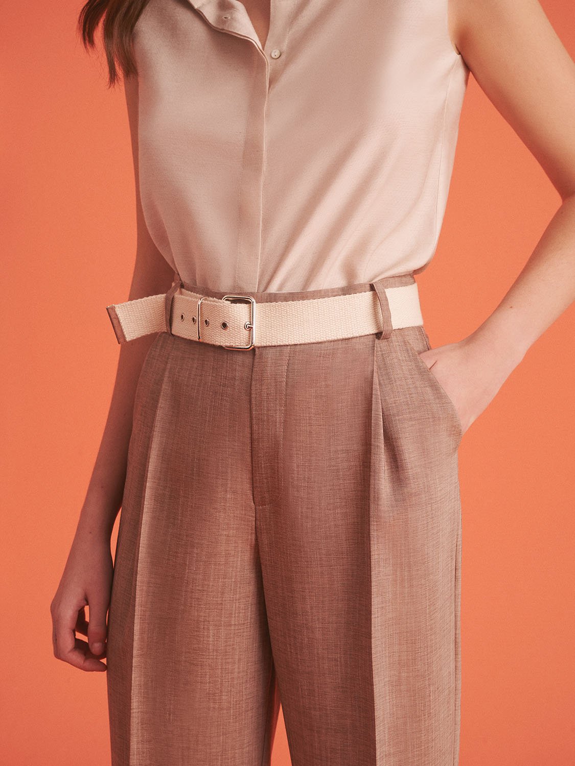 A pair of stylish ankle-length pleated high-waisted pants with a metal buckle belt, showcasing a chic design suitable for summer wear.