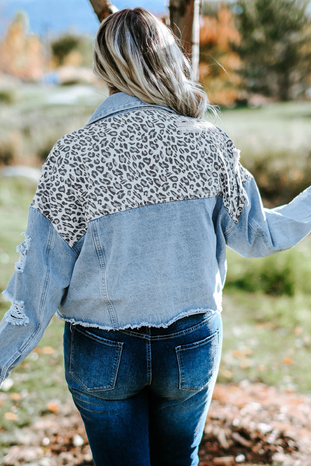 Plus size denim jacket featuring leopard print, distressed details, and raw hem, perfect for casual outdoor wear.