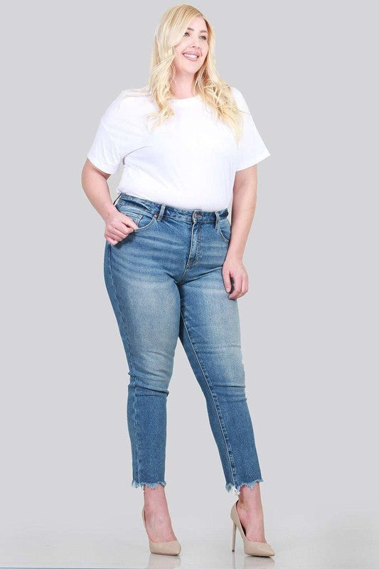 A pair of plus size relaxed skinny jeans featuring a high rise, zipper fly, ankle length with raw cut hem, and five pocket styling.