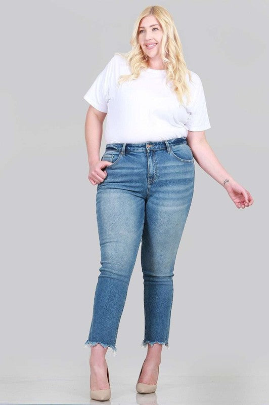 A pair of plus size relaxed skinny jeans featuring a high rise, zipper fly, ankle length with raw cut hem, and five pocket styling.