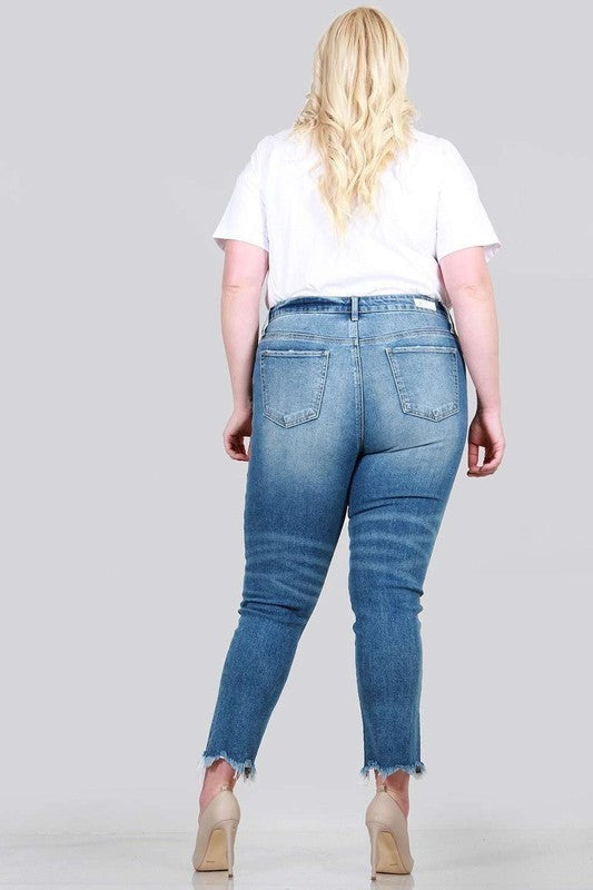 A pair of plus size relaxed skinny jeans featuring a high rise, zipper fly, ankle length with raw cut hem, and five pocket styling.