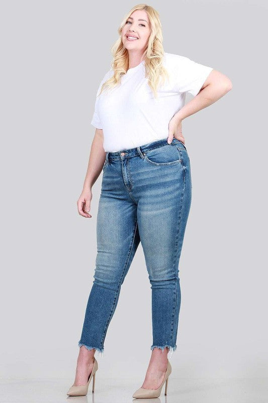 A pair of plus size relaxed skinny jeans featuring a high rise, zipper fly, ankle length with raw cut hem, and five pocket styling.