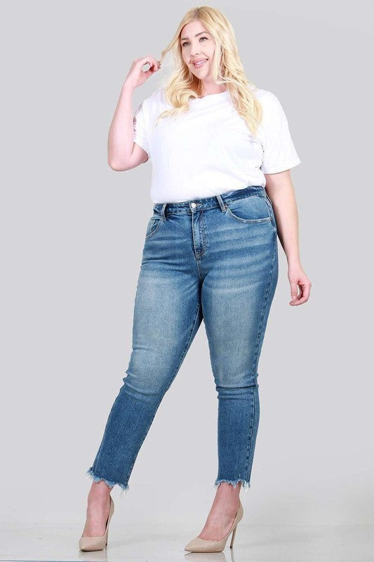 A pair of plus size relaxed skinny jeans featuring a high rise, zipper fly, ankle length with raw cut hem, and five pocket styling.