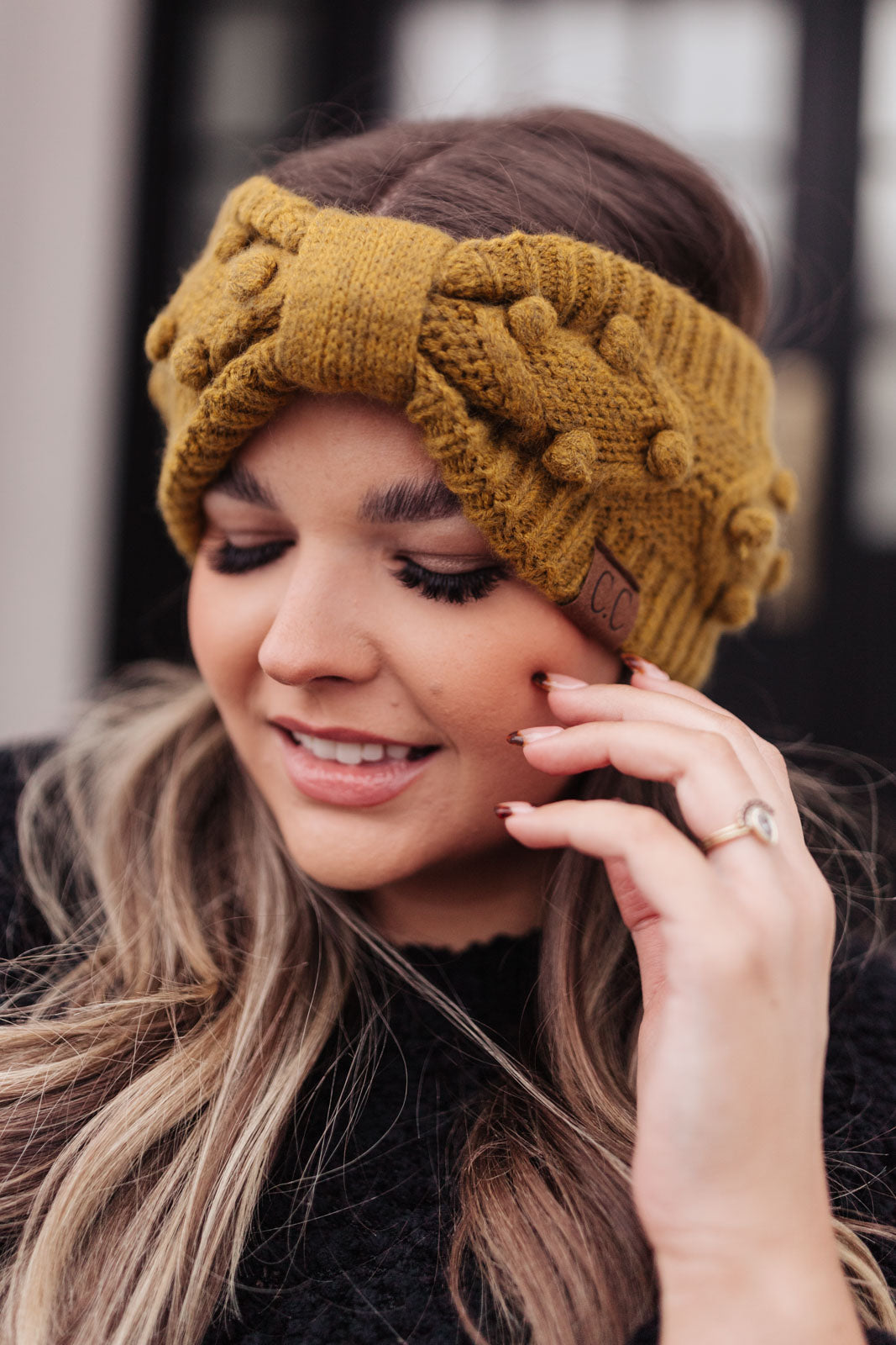 A stylish mustard-colored Pom Knit Head Wrap featuring handmade baubles, perfect for winter wear.