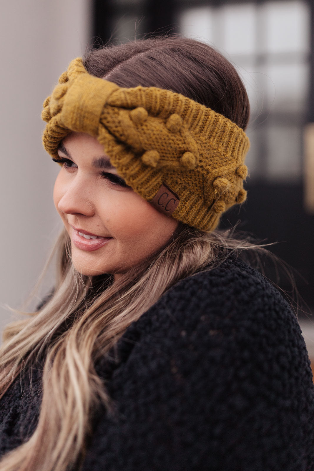 A stylish mustard-colored Pom Knit Head Wrap featuring handmade baubles, perfect for winter wear.