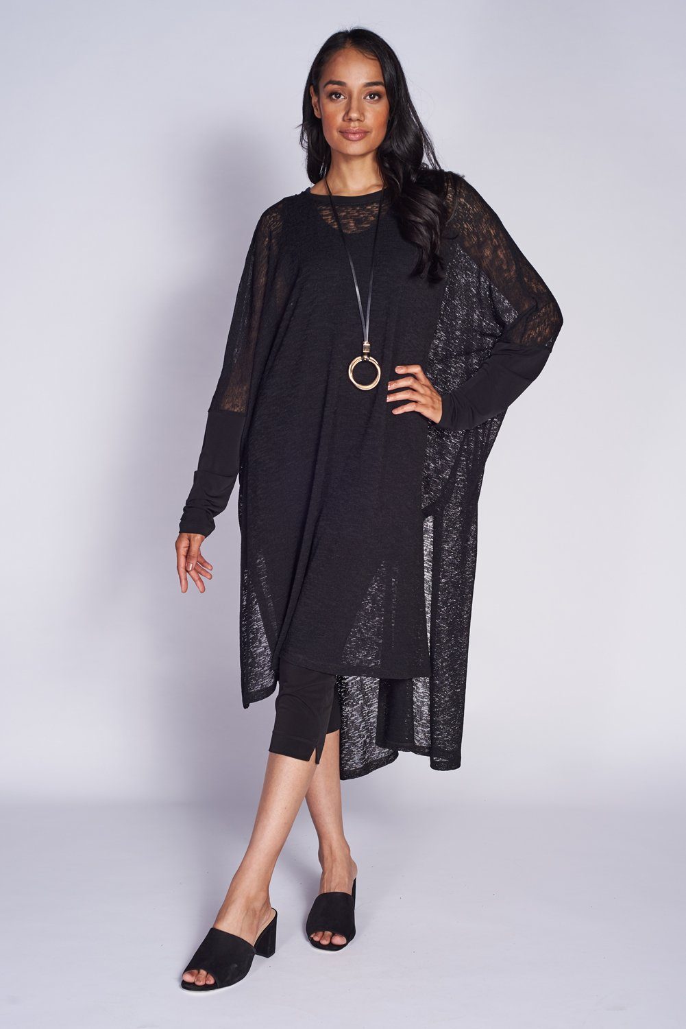 A stylish Poncho Dress made from textured mesh knit fabric, showcasing its versatile design and breathable material.