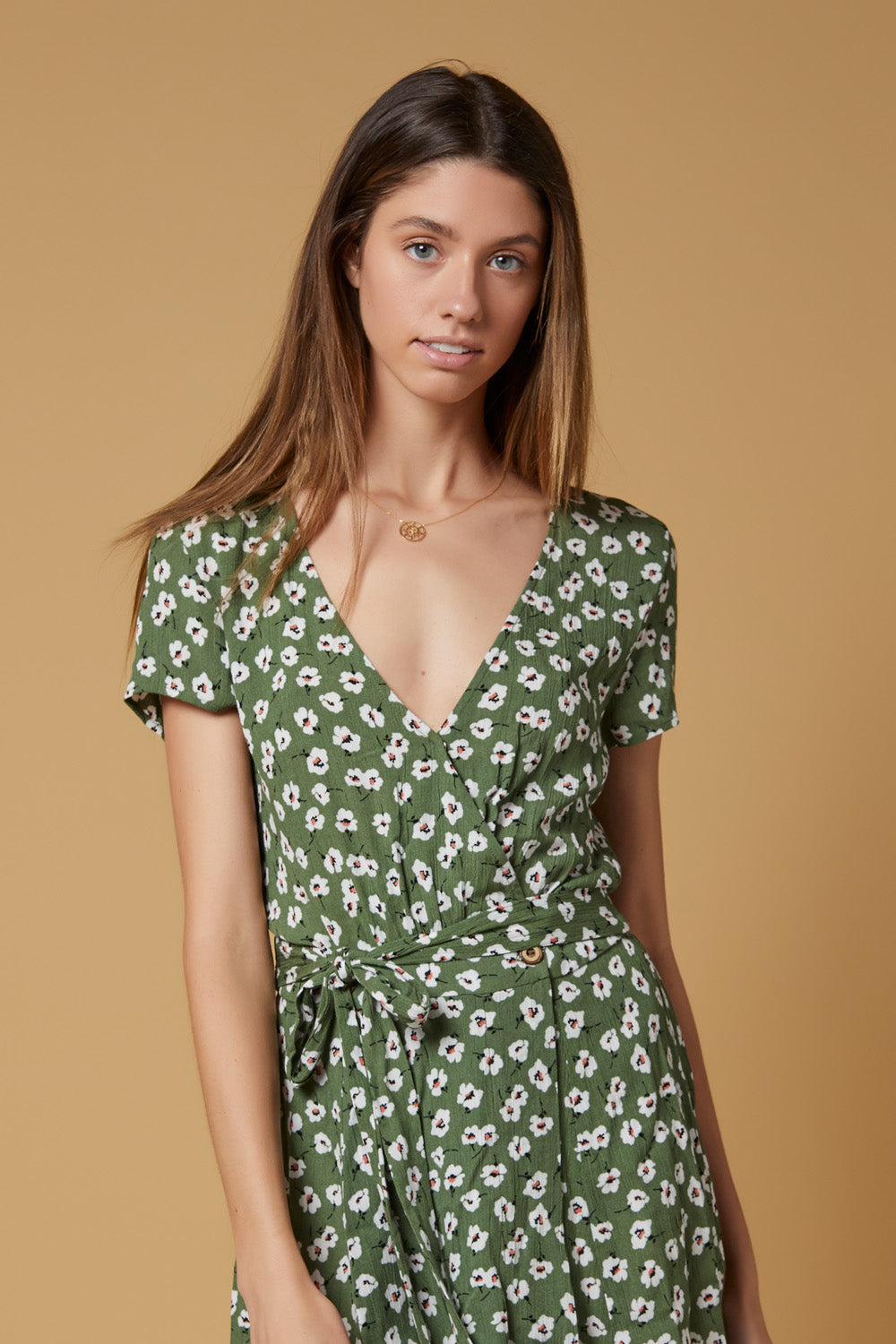 A stylish Poppy Wrap Dress featuring a vibrant floral pattern, snap closure, and wood buttons, perfect for summer outings.