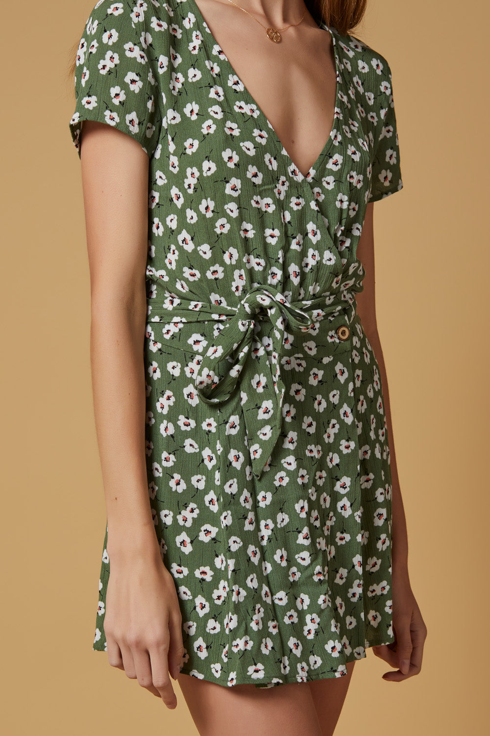 A stylish Poppy Wrap Dress featuring a vibrant floral pattern, snap closure, and wood buttons, perfect for summer outings.