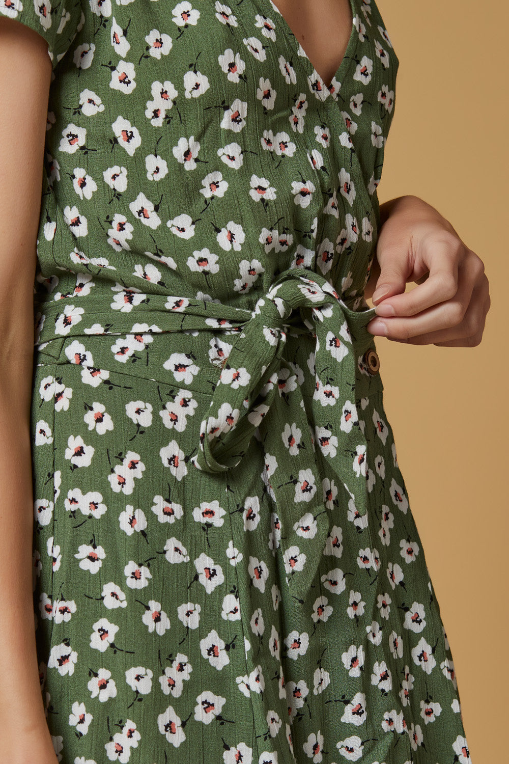 A stylish Poppy Wrap Dress featuring a vibrant floral pattern, snap closure, and wood buttons, perfect for summer outings.