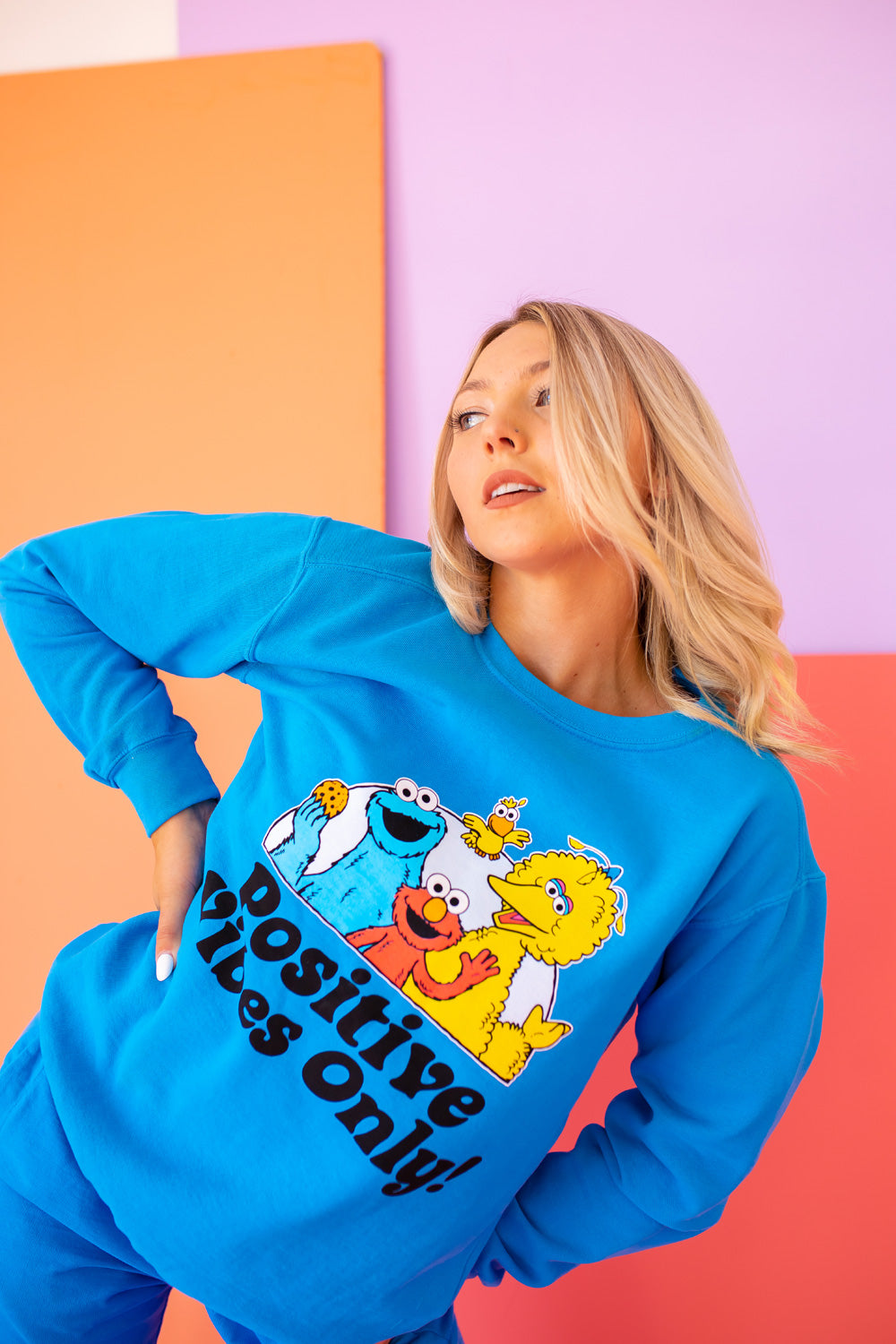 Positive Vibes Sesame Sweatshirt in blue featuring iconic Sesame Street characters, made from 100% upcycled cotton.