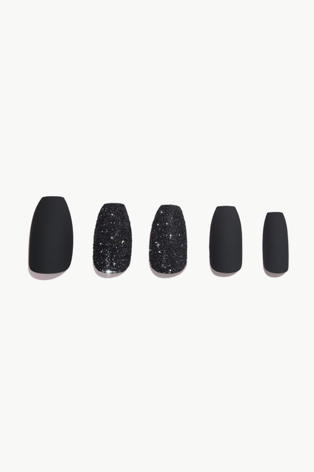 Press Nails in Rock the Road featuring a matte black finish with a red bottom and glitter accents, displayed in a stylish flat lay.