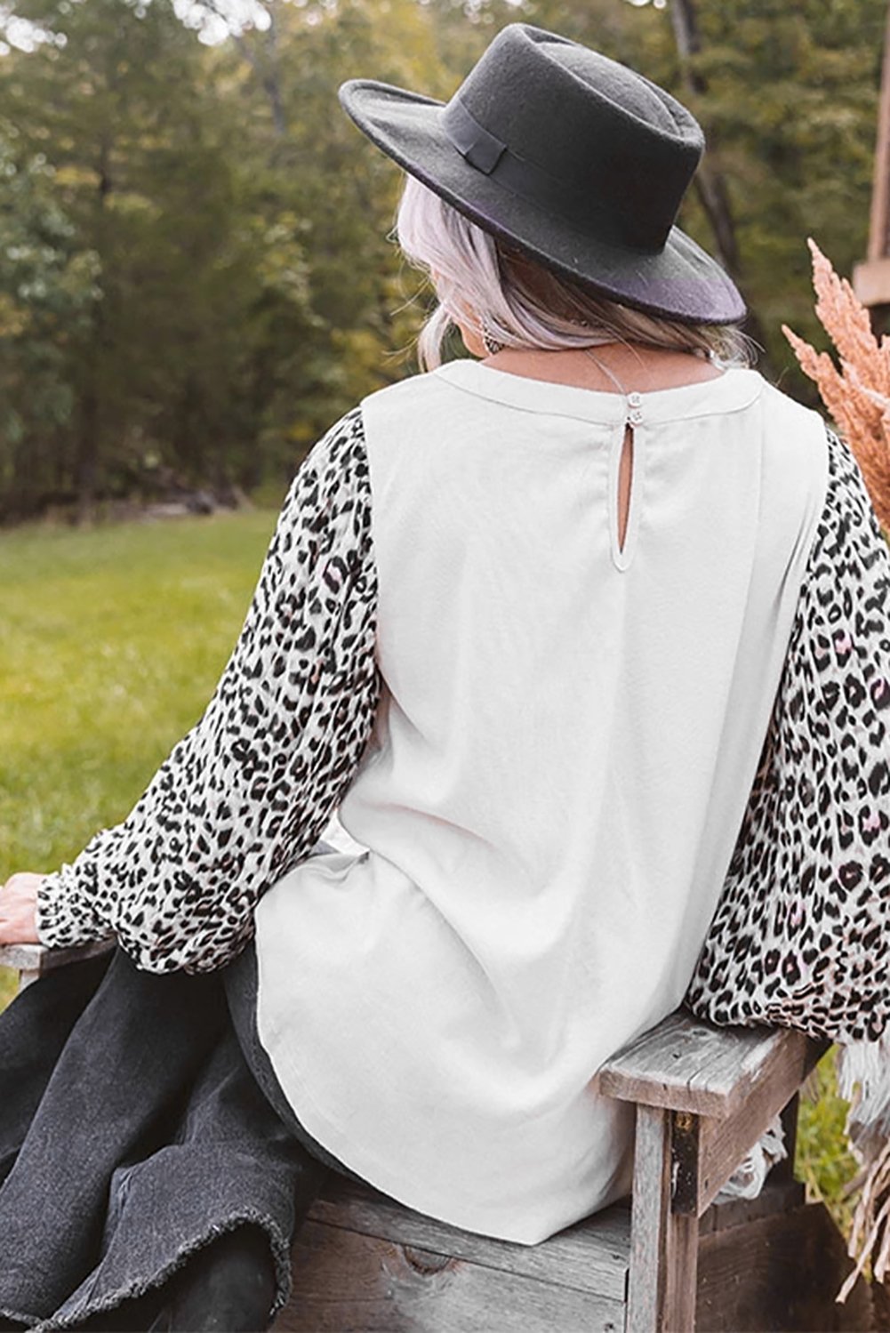 A stylish Print Crew Neck Puff Sleeve Top featuring a bold leopard print pattern in black and light neutral tones, with smocked cuffs and a keyhole back.