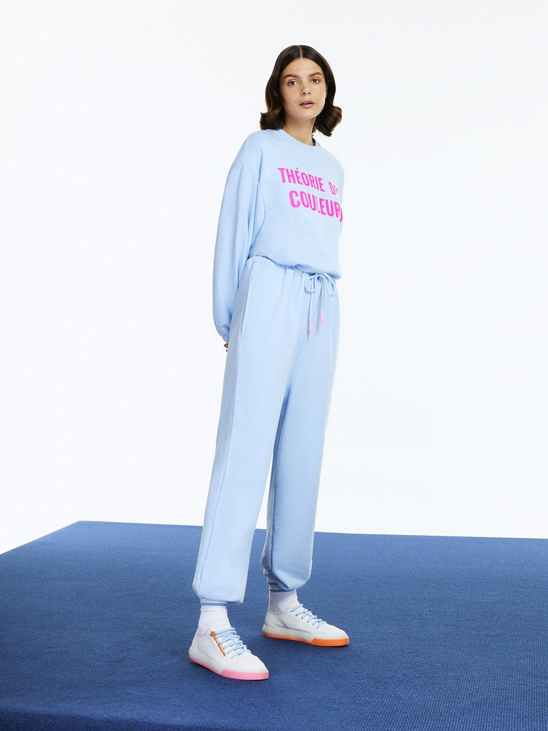 A vibrant Printed Knit Jumpsuit featuring a crew neck, long sleeves, and colorful text print, designed for comfort and style.