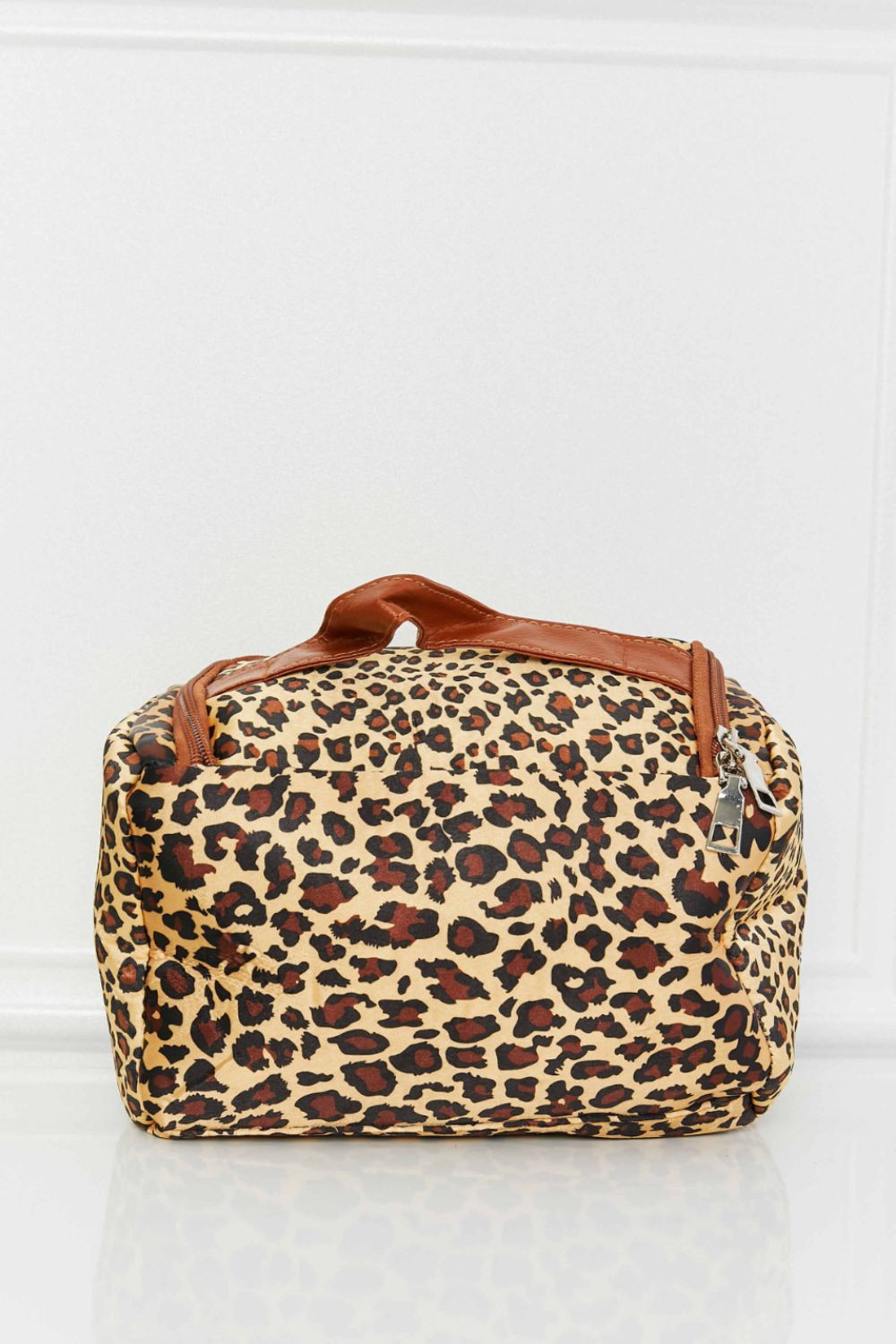 A stylish printed makeup bag featuring leopard and plaid patterns, equipped with a top handle strap for easy carrying.