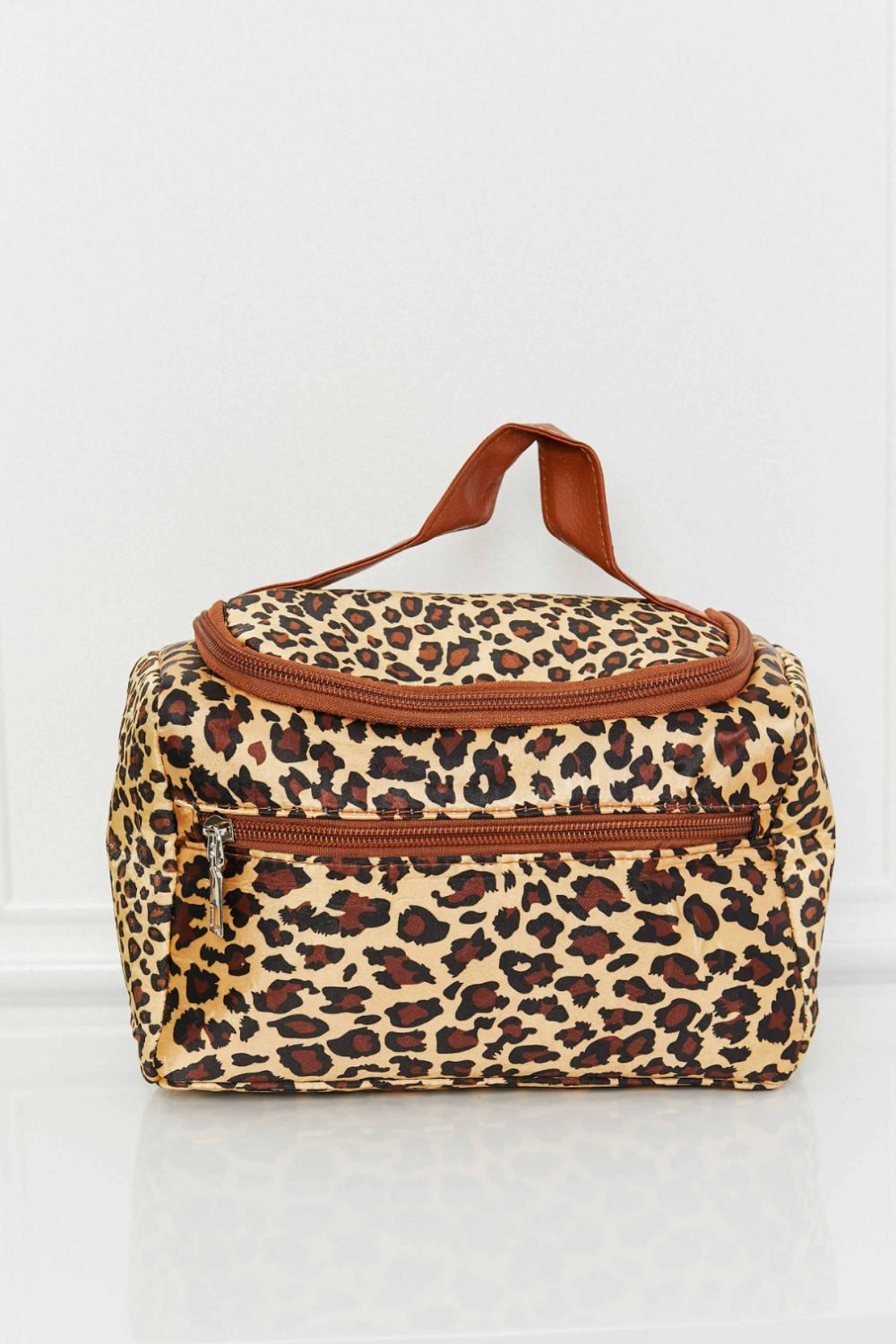 A stylish printed makeup bag featuring leopard and plaid patterns, equipped with a top handle strap for easy carrying.