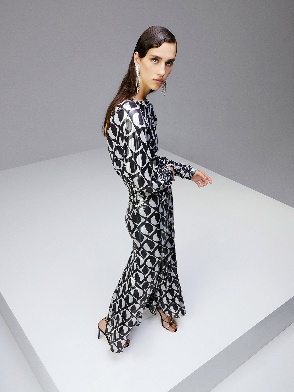 A stylish Printed Open Back Dress featuring a boat neck, long batwing sleeves, and a flowy back with a tie closure, showcasing a chic monochrome pattern.