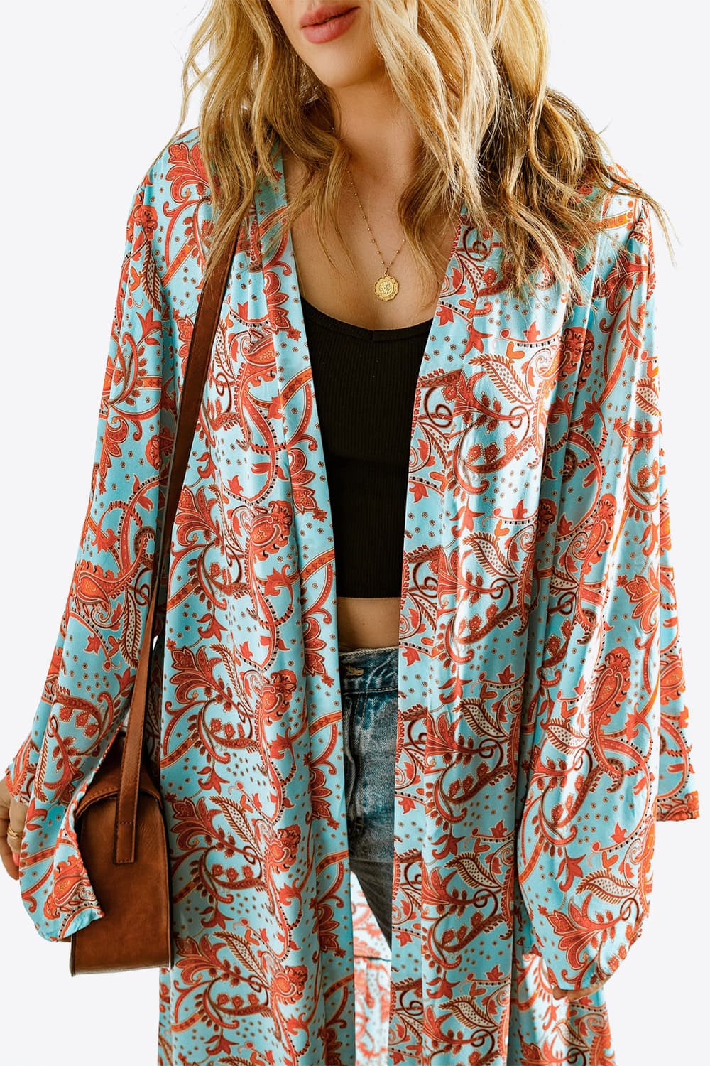 A stylish Printed Open Front Duster Cardigan featuring a floral pattern, ruffle details, and long flare sleeves, perfect for layering.