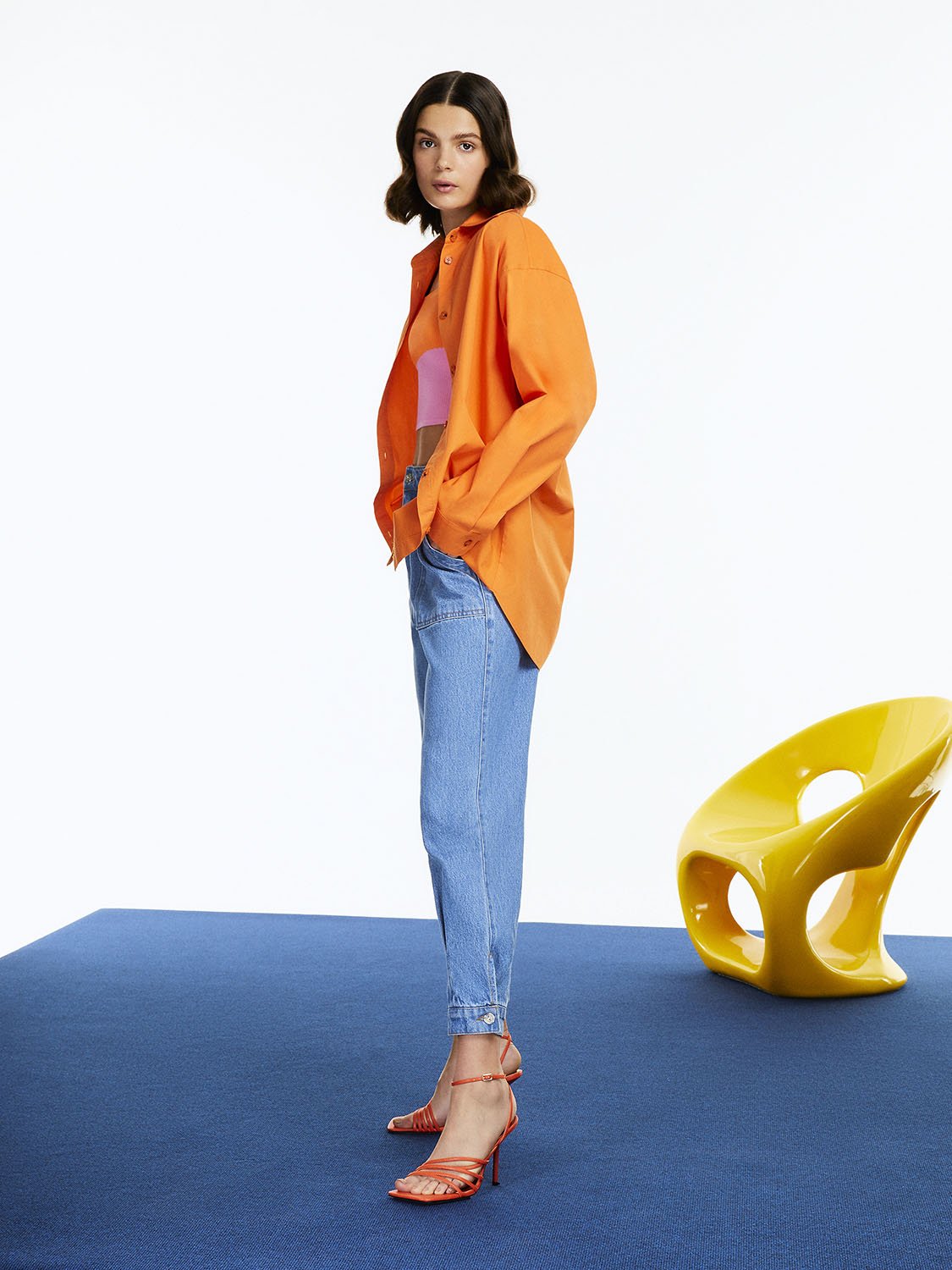 A vibrant Printed Oversized Shirt featuring orange, pink, and blue colors with long sleeves and a printed text detail on the back.