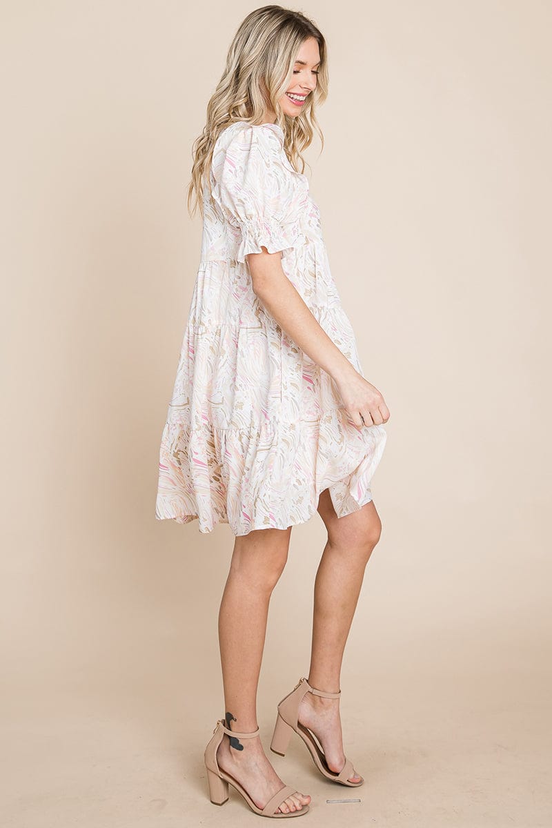 A stylish Printed Ruffle Short Sleeve Tiered Swing Dress featuring layered design, short puff sleeves, and vibrant abstract print with side pockets.