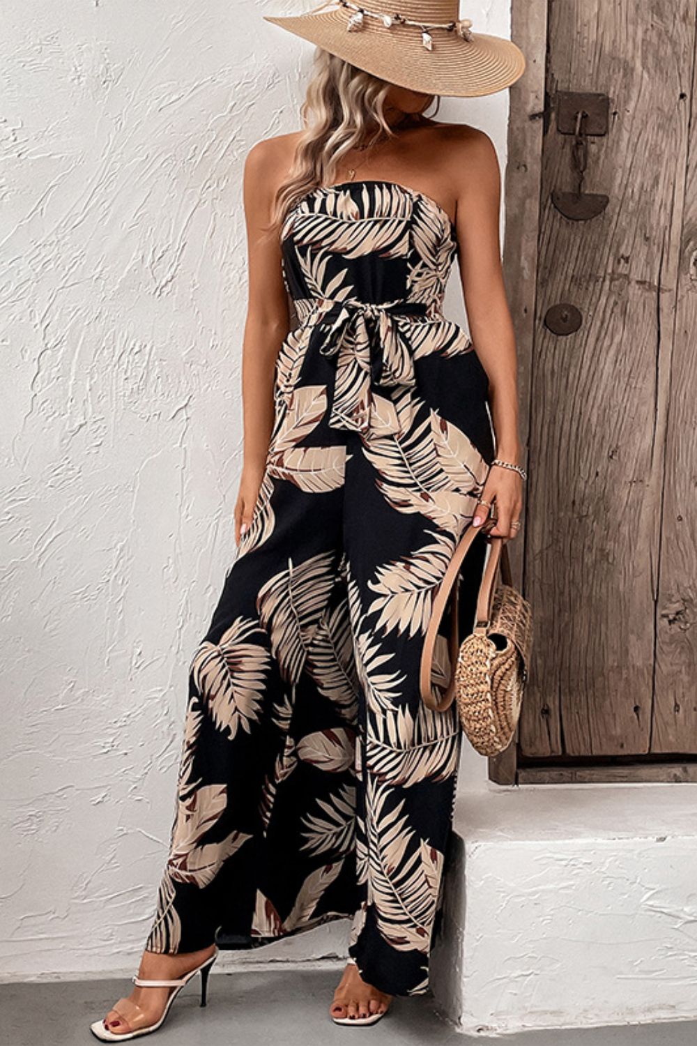 A stylish printed strapless wide leg jumpsuit with pockets, featuring a belted waist and sleeveless design, perfect for chic urban outings.