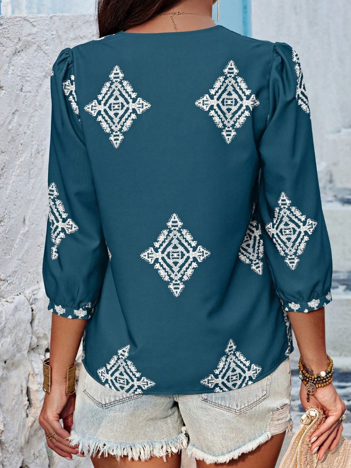 A stylish Printed V-Neck Three-Quarter Sleeve Blouse featuring a vibrant print, designed for comfort and elegance, made from 100% polyester.