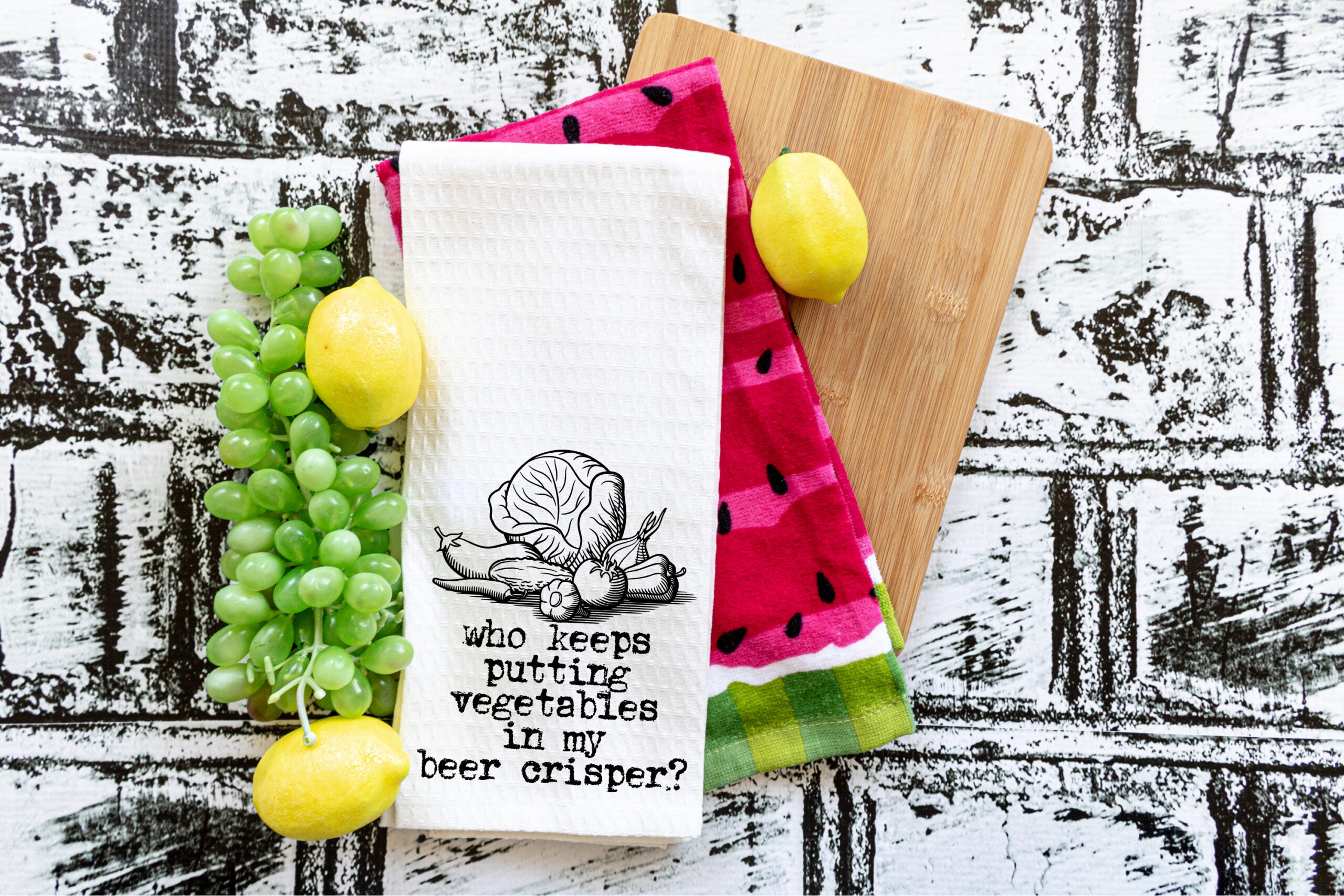 A collection of colorful Punny Tea Towels featuring humorous sayings, made from 100% cotton, displayed in a bright kitchen setting.