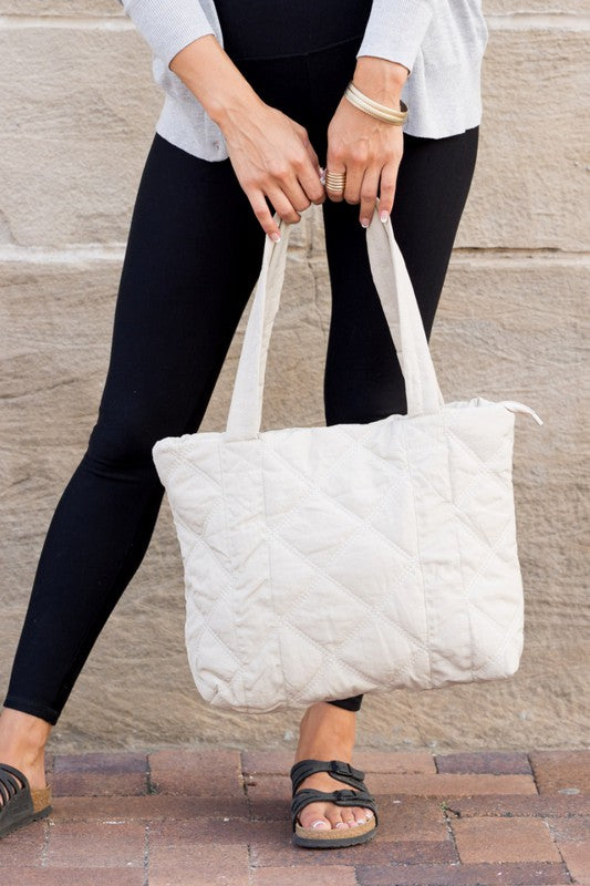 Stylish Quilted Tote with puffed design, top zipper closure, and three interior pockets, perfect for everyday use.