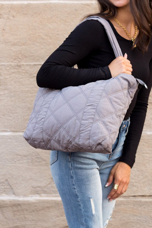 Stylish Quilted Tote with puffed design, top zipper closure, and three interior pockets, perfect for everyday use.