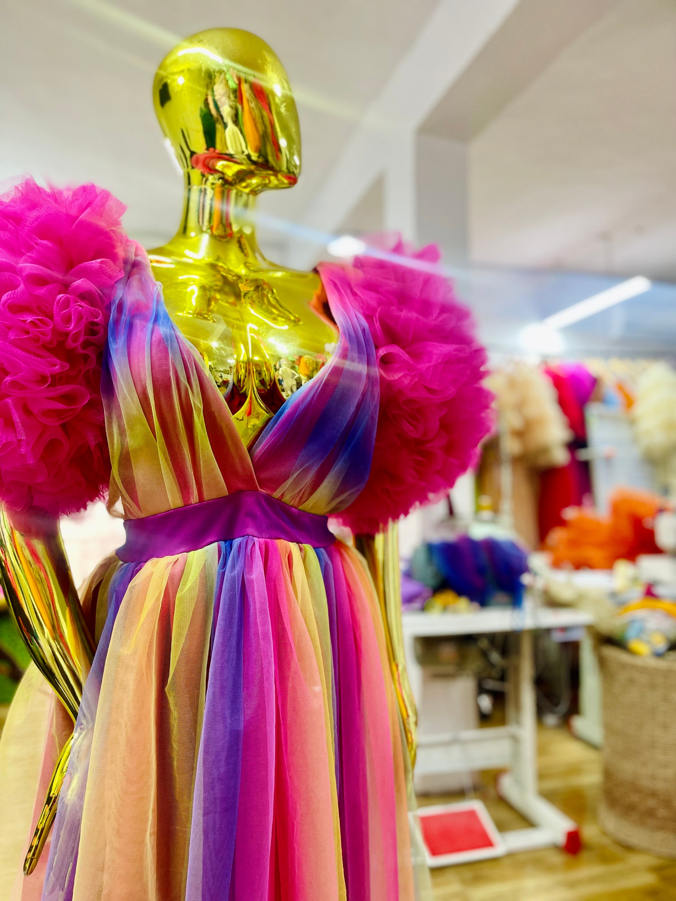 A vibrant Rainbow Ixora Dress featuring puffy ruffle sleeves and a stylish slit, perfect for all occasions.