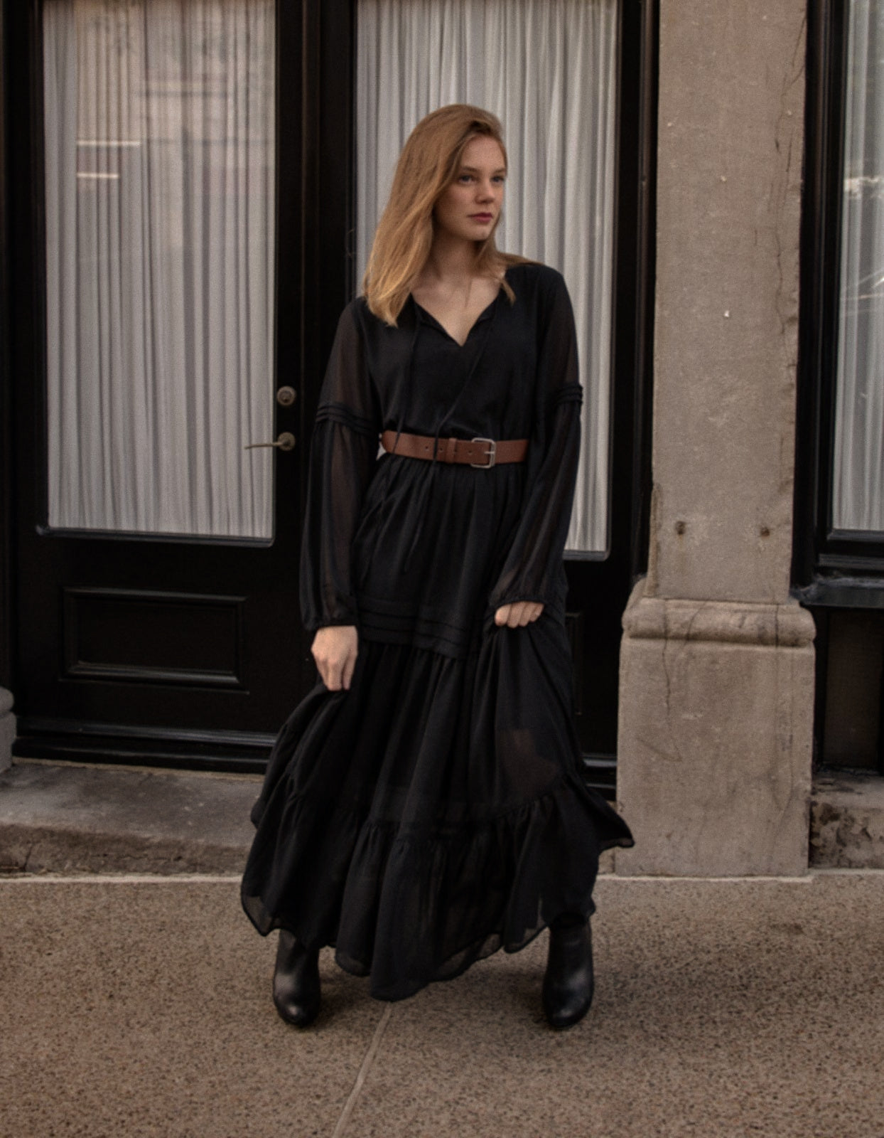 Raissa Midi Dress in solid black featuring a tiered skirt, semi-sheer sleeves, and a keyhole neckline detail.