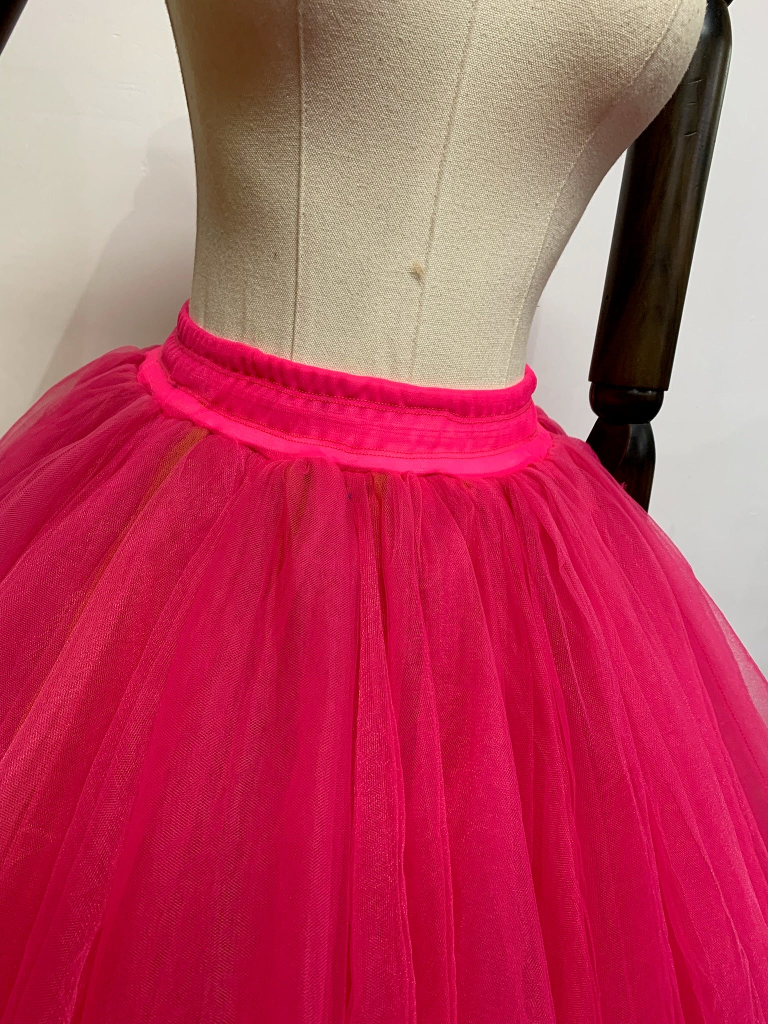 A fluffy tulle skirt in a soft pastel color, showcasing layers of delicate fabric for a whimsical and elegant look.