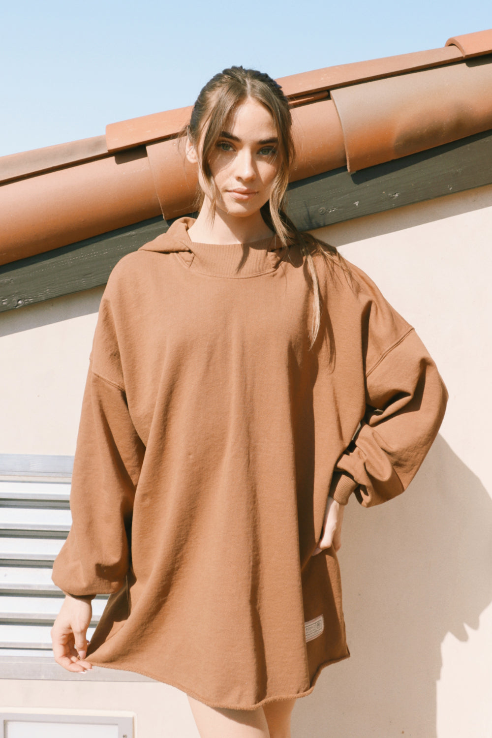 A cozy oversized bell-shaped hoodie in saddle color, made from 100% cotton, perfect for casual wear.