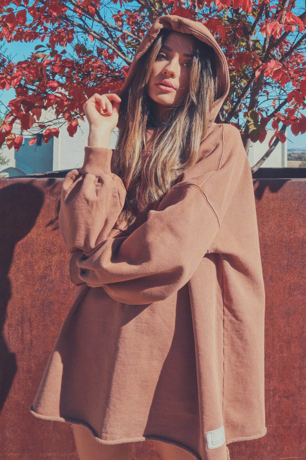 A cozy oversized bell-shaped hoodie in saddle color, made from 100% cotton, perfect for casual wear.