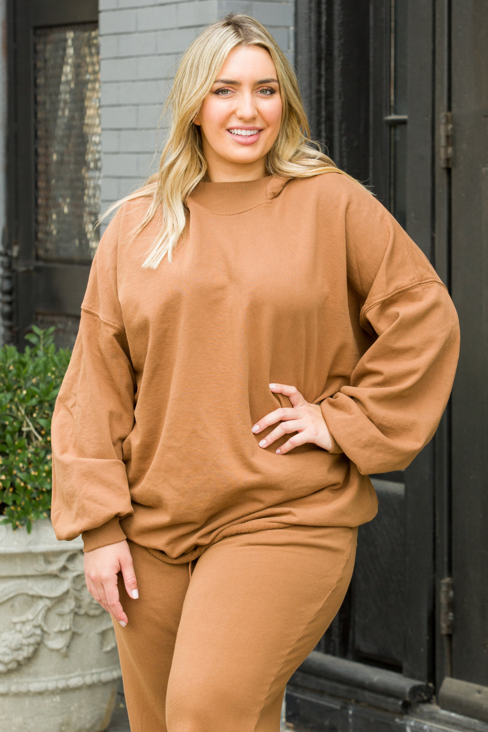 A cozy oversized bell-shaped hoodie in saddle color, made from 100% cotton, perfect for casual wear.