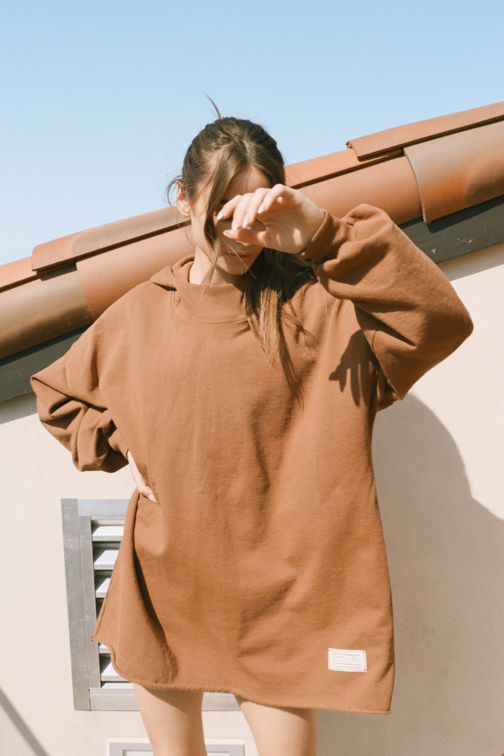 A cozy oversized bell-shaped hoodie in saddle color, made from 100% cotton, perfect for casual wear.