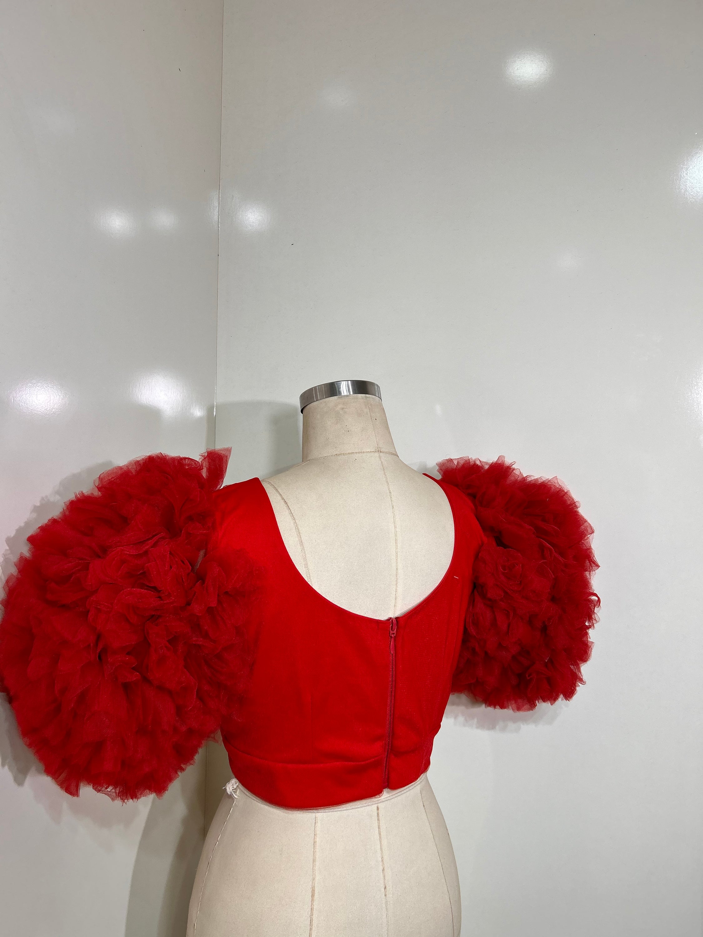 A vibrant red tulle top featuring a plunging neckline and cropped design, perfect for stylish occasions.