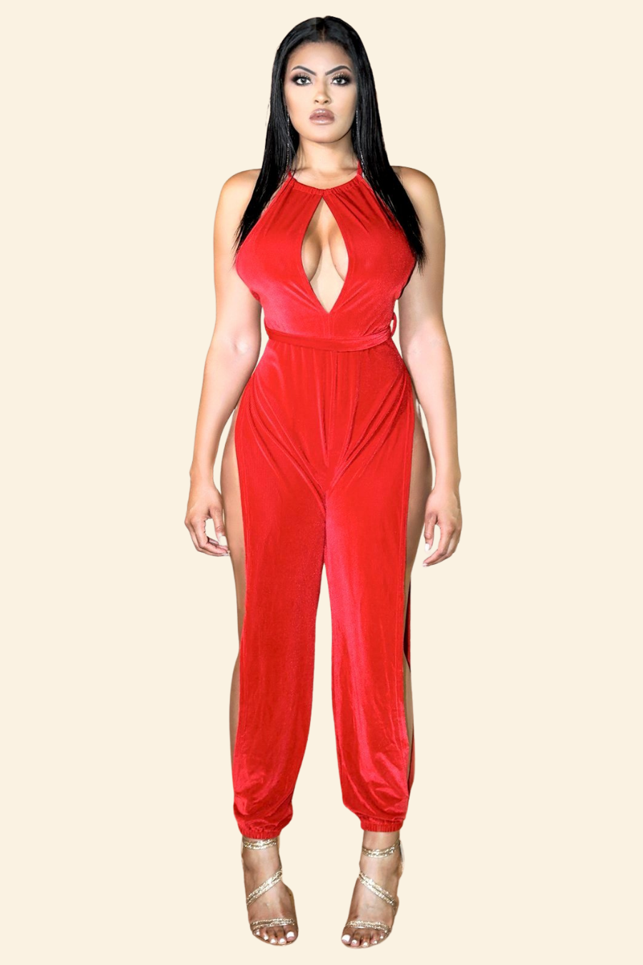 A stylish red velvet rib jumpsuit featuring open side leg slits and a deep keyhole neckline, tied at the back with a belt around the waist.