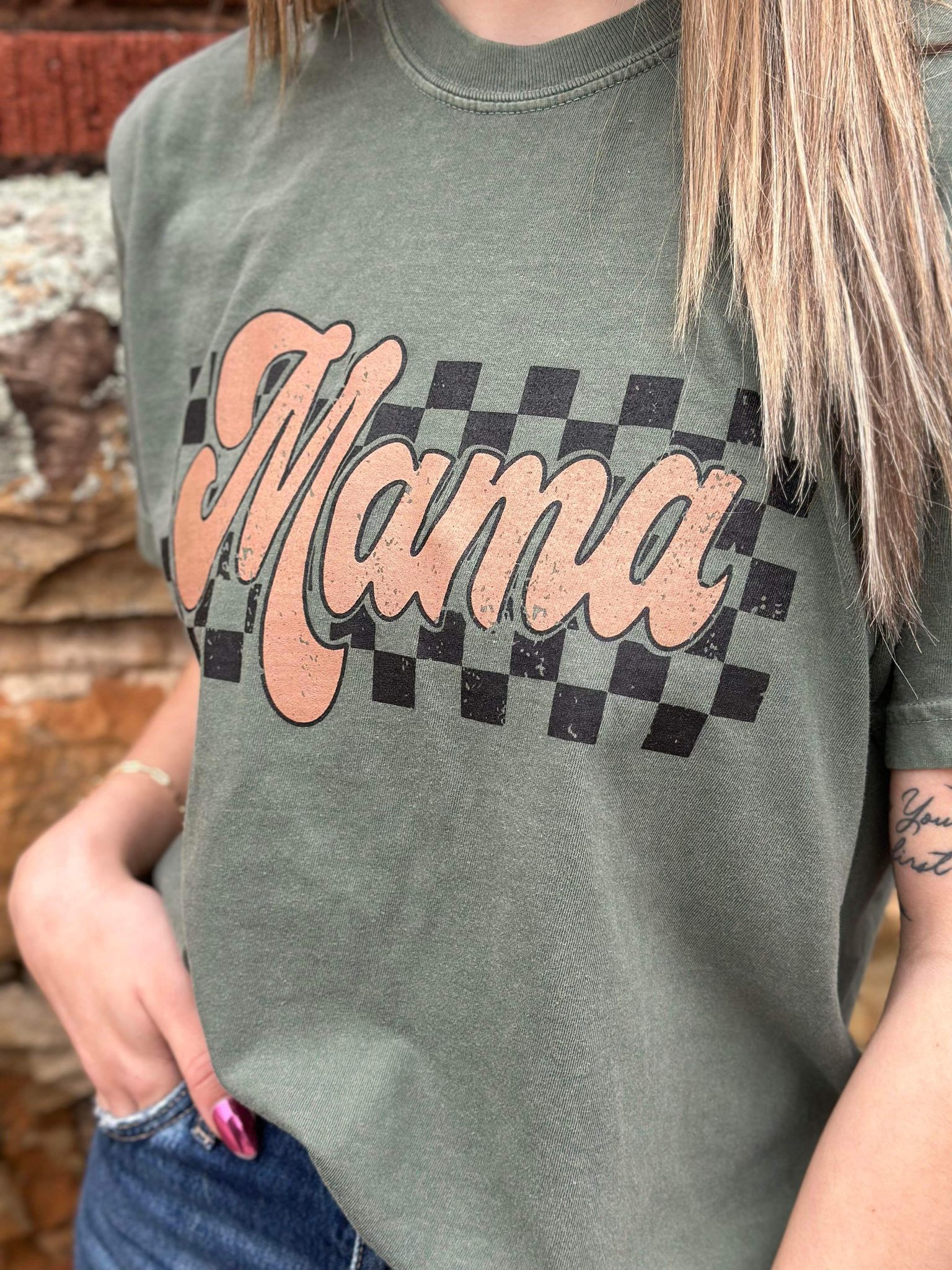 A stylish Retro Checkered Mama Tee in moss color, featuring a trendy checkered design, made from 100% cotton for comfort.