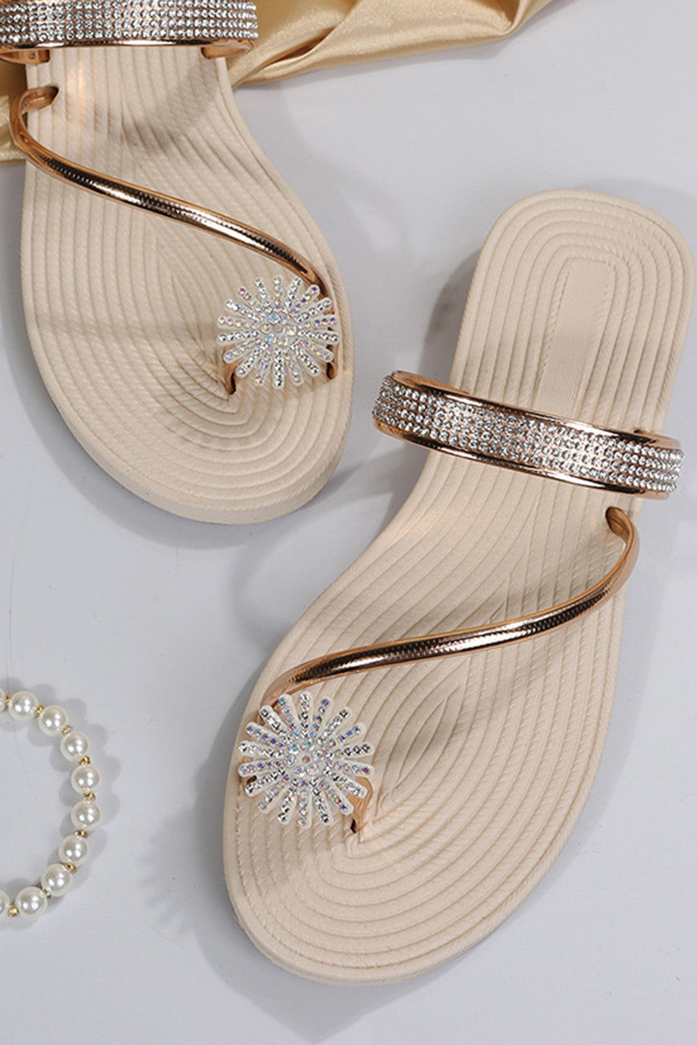 Stylish gold rhinestone sandals with flat soles and decorative straps, perfect for summer wear.