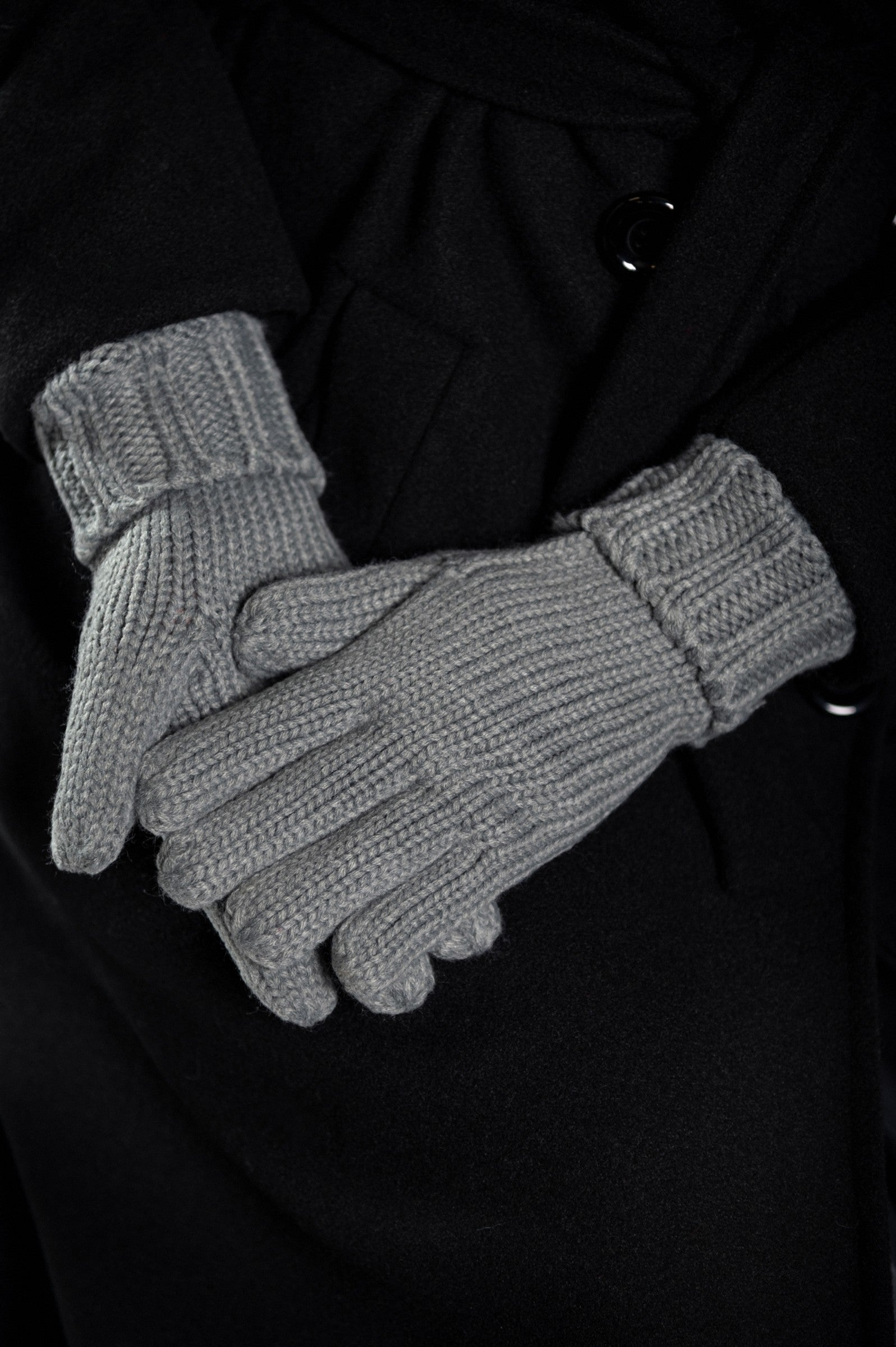 Stylish grey knitted gloves with a wide cuff, perfect for winter fashion.