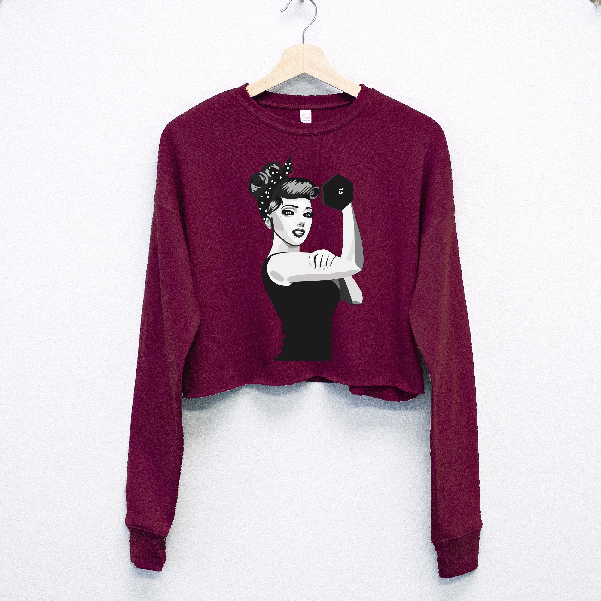 A stylish cropped sweater featuring the iconic Rosie the Riveter design, available in gray, burgundy, and mauve colors with a raw hem.