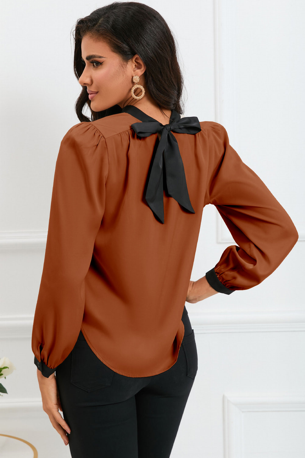 Round neck blouse with puff sleeves and back tie detail, showcasing a solid color design.