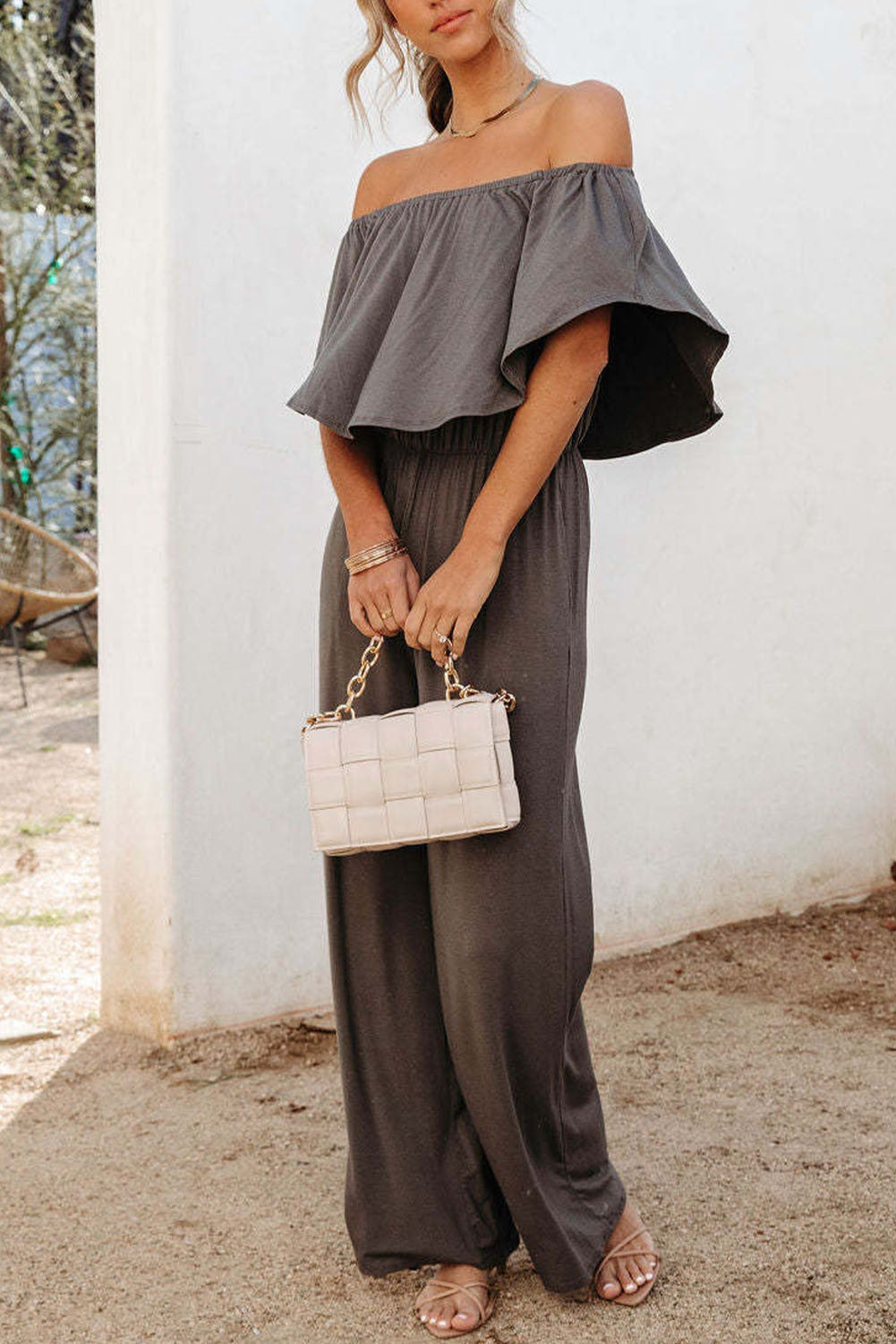 Stylish gray ruffle jumpsuit featuring an elastic frill around the shoulders and long baggy pants, perfect for casual or dressy occasions.