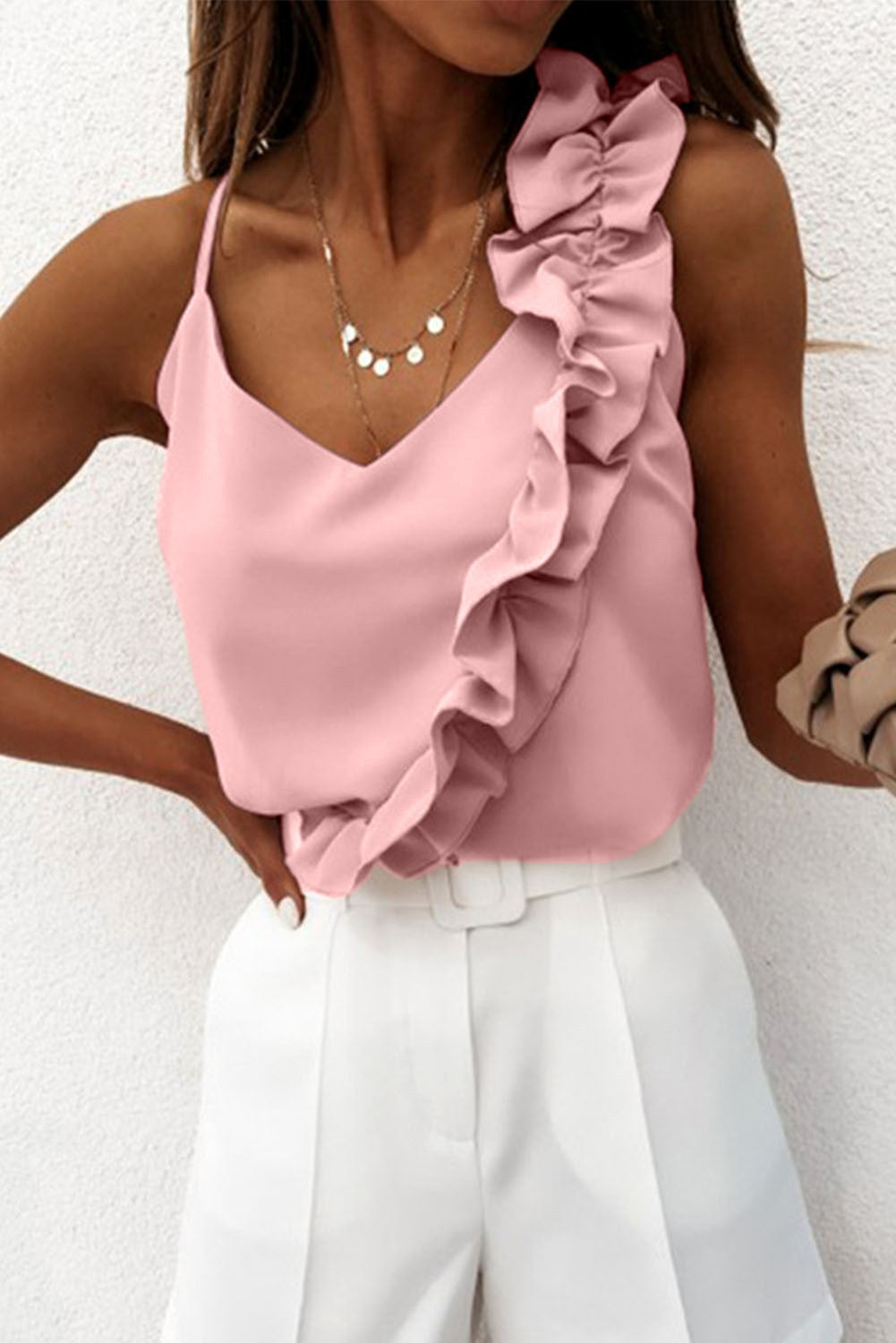 Light pink ruffle top with spaghetti straps and deep neckline, showcasing elegant design and high-quality fabric.