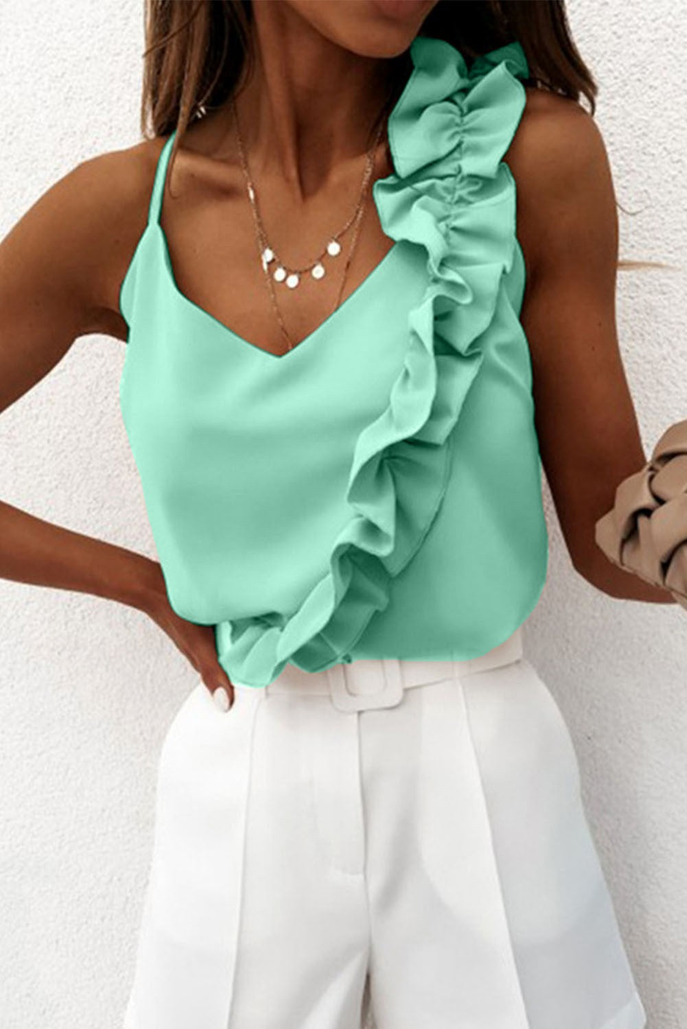 Elegant mint ruffled top with spaghetti straps, showcasing decorative ruffles and a deep neckline, made in Italy.