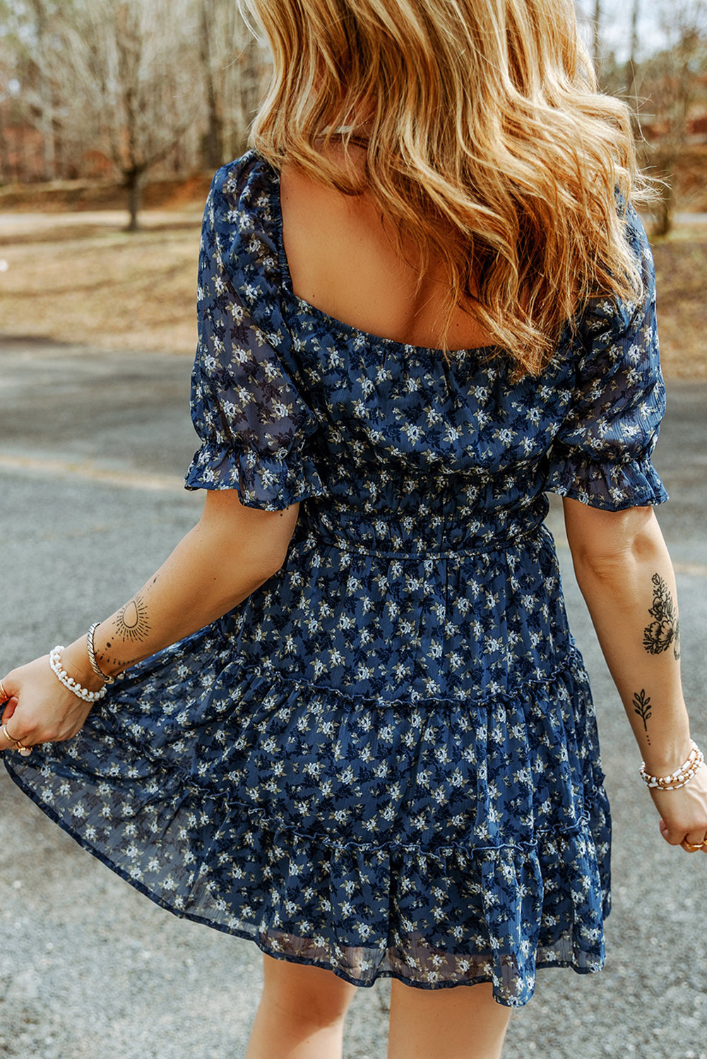 A stylish Sail Blue Floral Smocked Tiered Ruffle Short Dress featuring a floral print, smocked bodice, and tiered ruffle details, perfect for summer occasions.