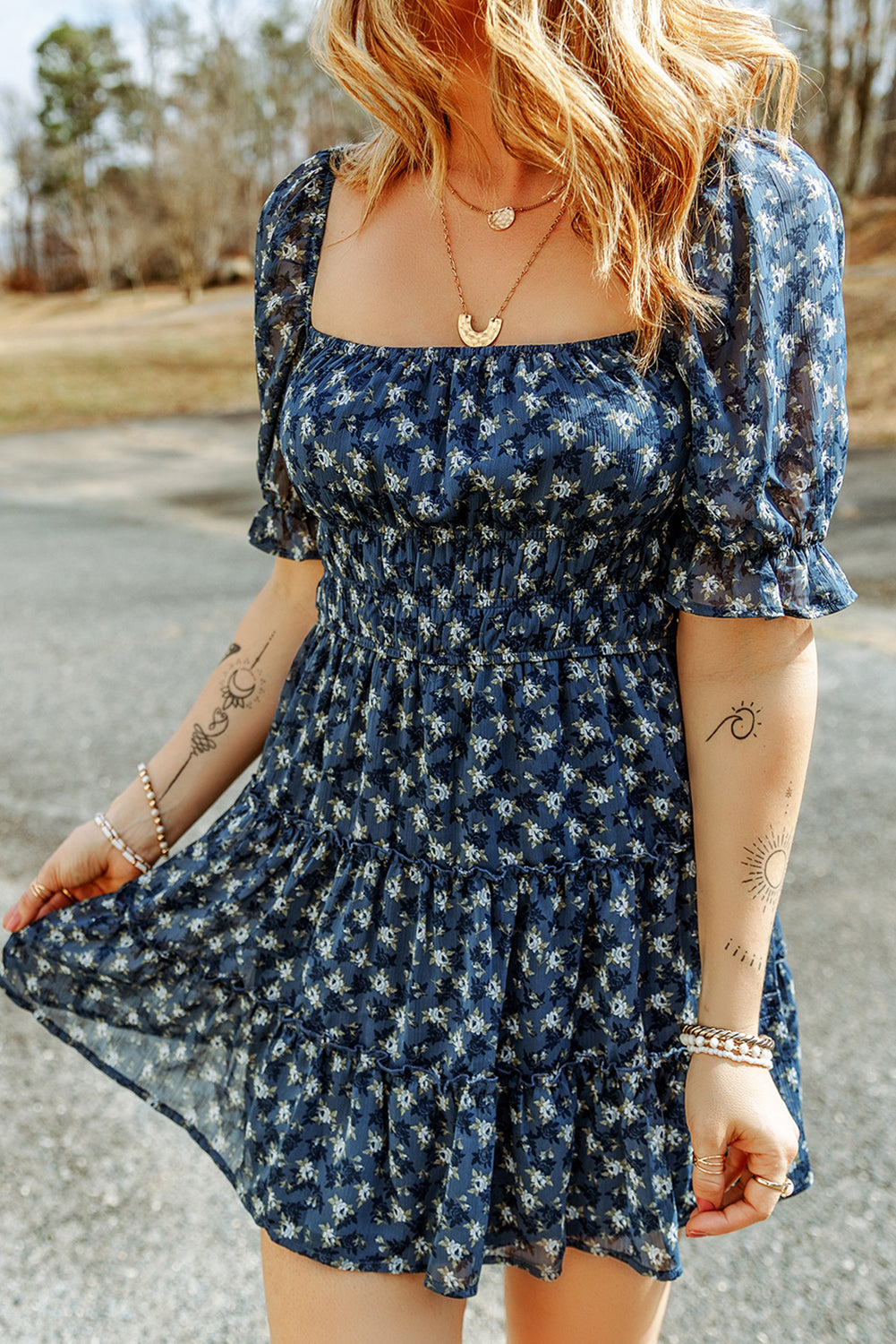 A stylish Sail Blue Floral Smocked Tiered Ruffle Short Dress featuring a floral print, smocked bodice, and tiered ruffle details, perfect for summer occasions.