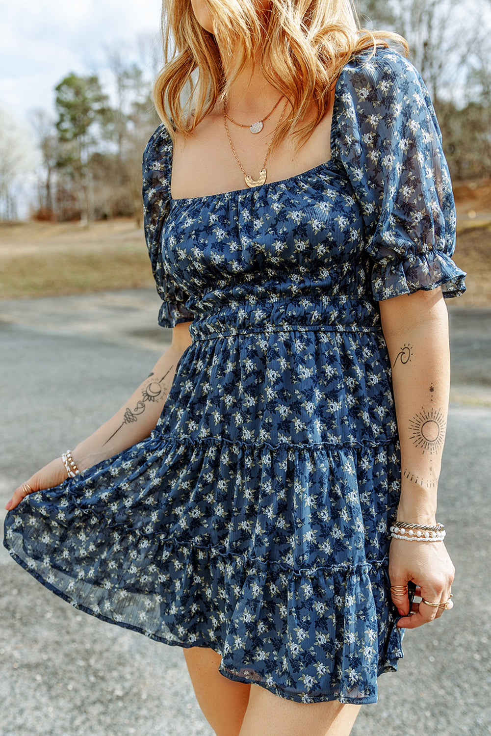 A stylish Sail Blue Floral Smocked Tiered Ruffle Short Dress featuring a floral print, smocked bodice, and tiered ruffle details, perfect for summer occasions.