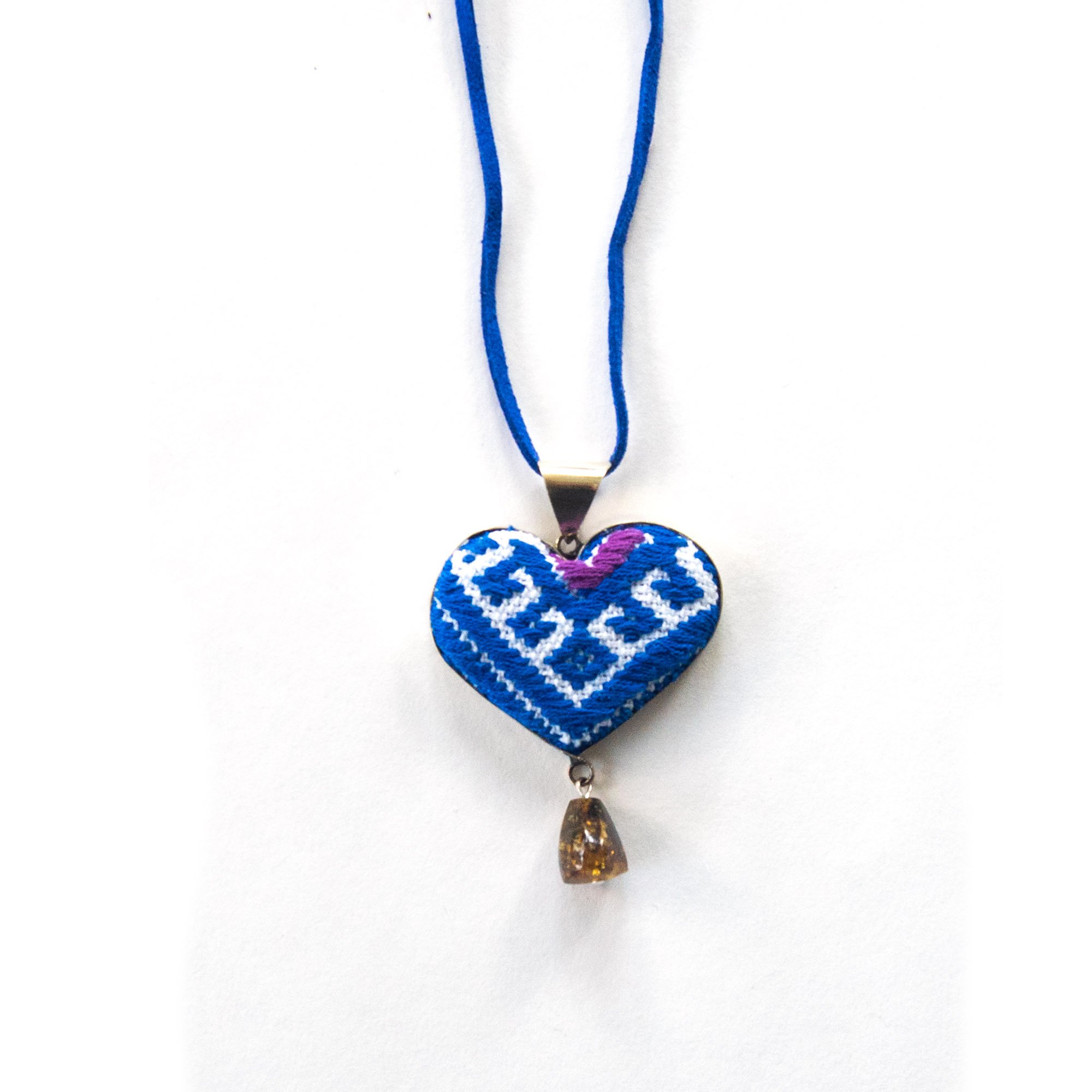 San Andres Blue Heart Textile Necklace featuring an amber stone, handcrafted with vibrant colors and intricate designs by artisans from Chiapas, Mexico.